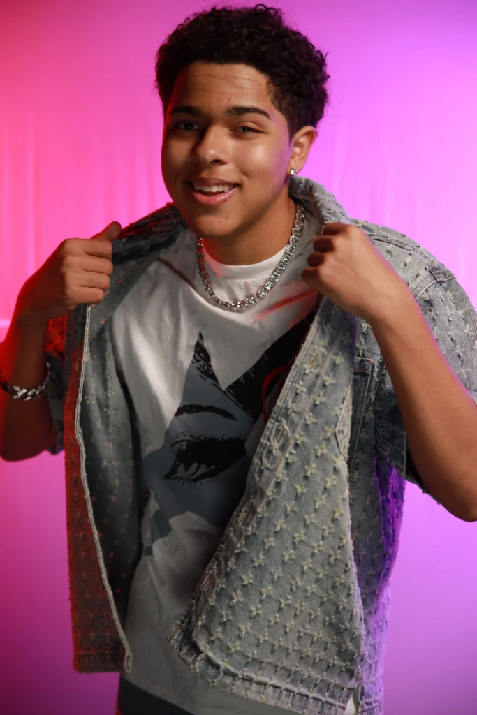 Jay Gallant standing fluffing the collar of his jacket and facing the camera.